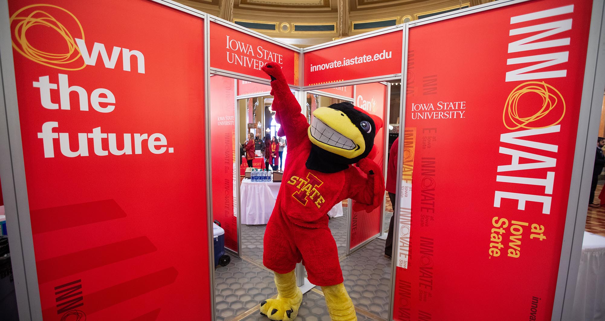 Cy the Mascot poses with the Innovation display during ISU's Day at the Capitol event.