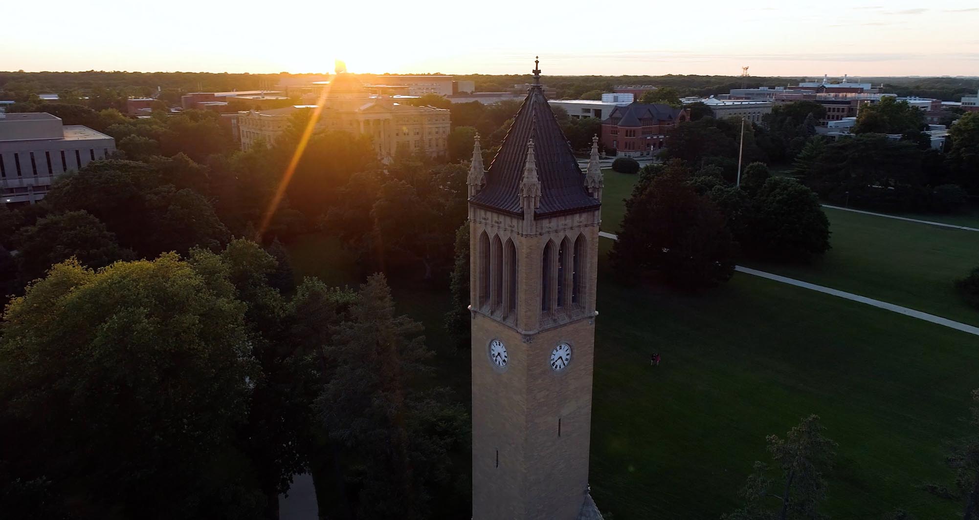 Drone view of the sun setting behind the campanile.
